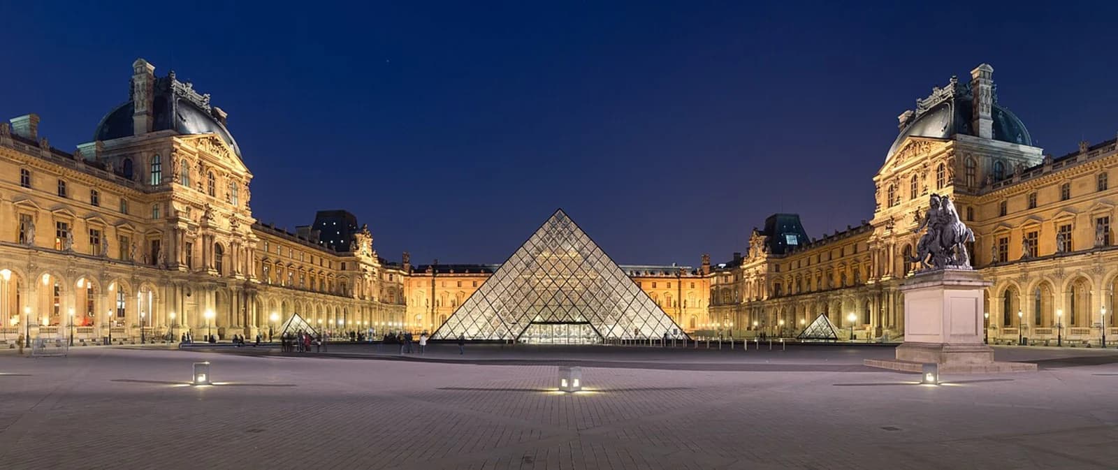 The glass pyramid of the Musee du Louvre illuminated at dusk in the Cour Napoleon, Paris