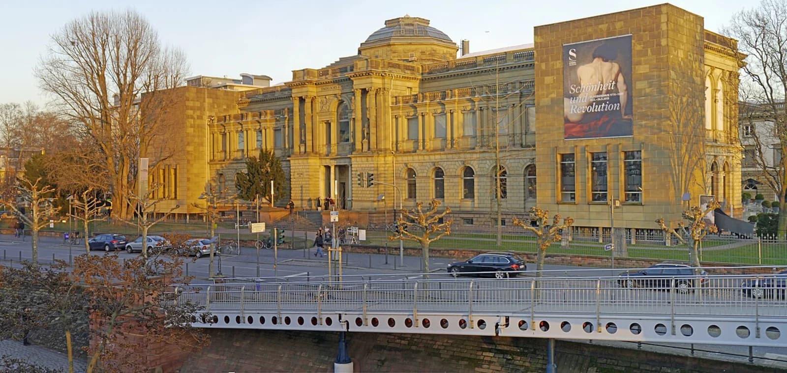Städel Museum Frankfurt am Main, viewed from across the River Main, showing the full neoclassical facade and the modern underground extension skylights in the garden