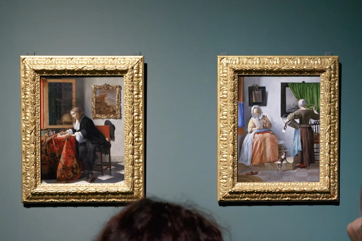 Two gold-framed genre paintings by Gabriel Metsu on a teal wall, a man writing a letter and a woman reading one