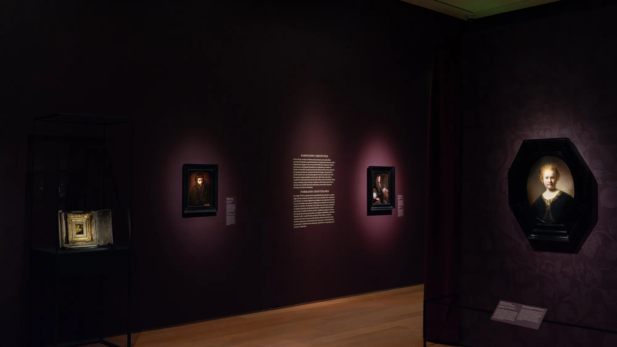 Installation view of Art and Life in Rembrandt's Time at the Norton Museum of Art, with the bilingual 'Fashioning Identities' wall text and Dutch portraits
