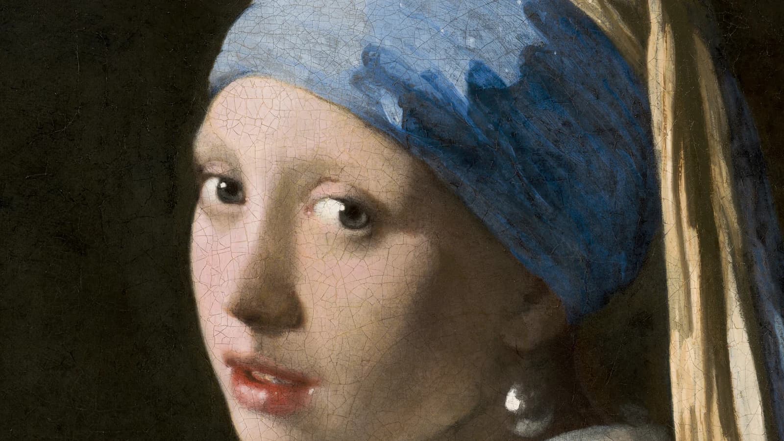 Close detail of Girl with a Pearl Earring, her face and blue turban set against a dark background where a green curtain once hung