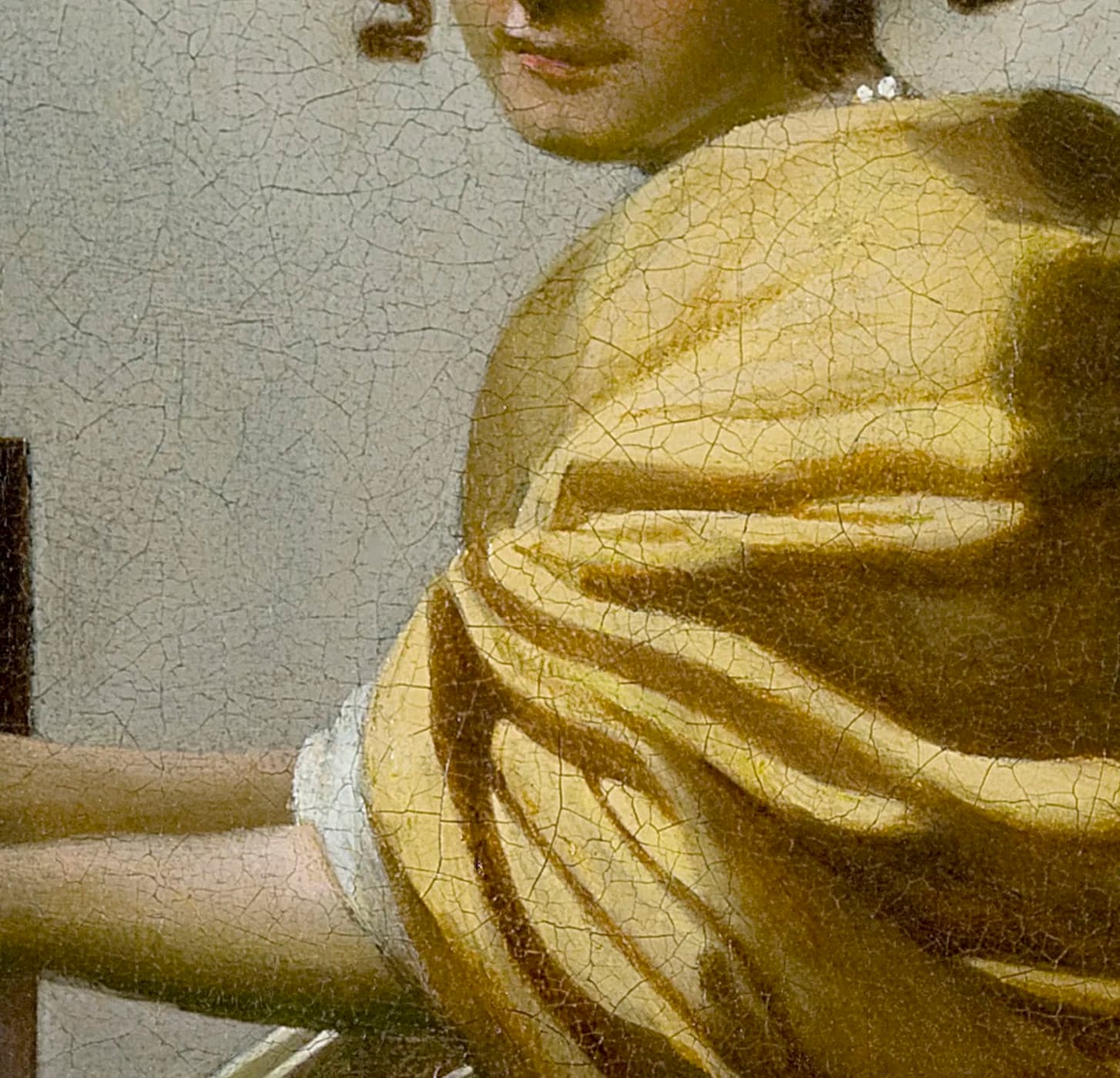 Detail of the yellow shawl draped over the woman's shoulder, with the white of her undergarment showing at the lower left