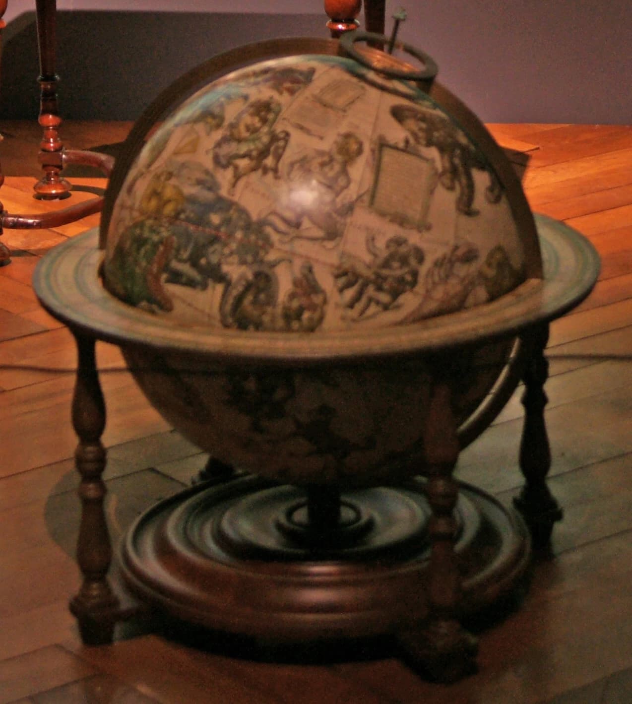 A celestial globe after Jodocus Hondius, its surface painted with the constellation figures, on a turned wooden stand