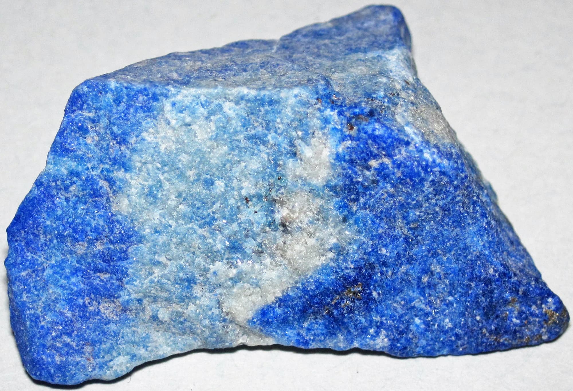 A specimen of lapis lazuli rock from the Sar-e-Sang deposit in Afghanistan, deep blue lazurite flecked with white calcite and brassy pyrite